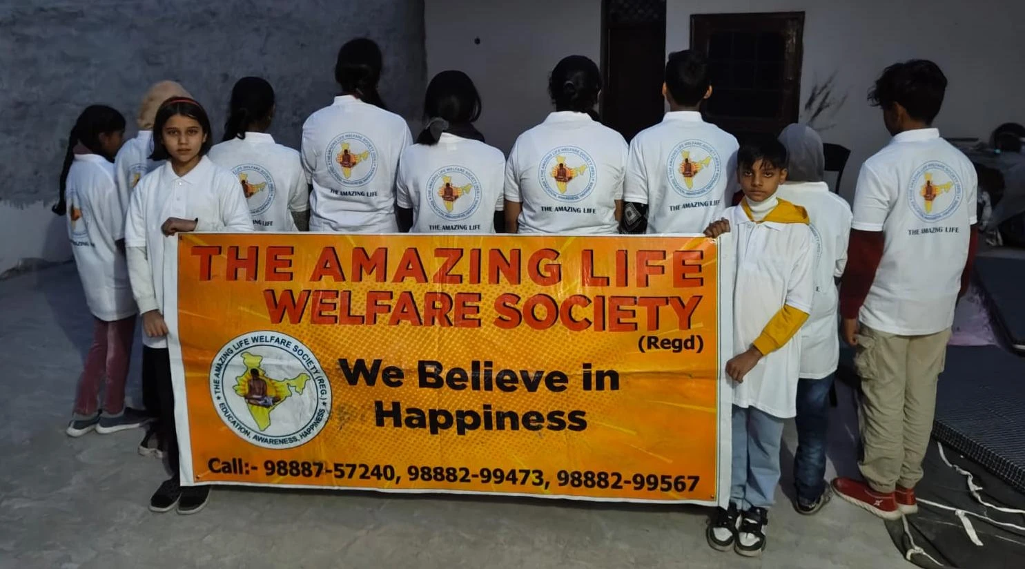 Children holding the Society’s “We Believe in Happiness” banner