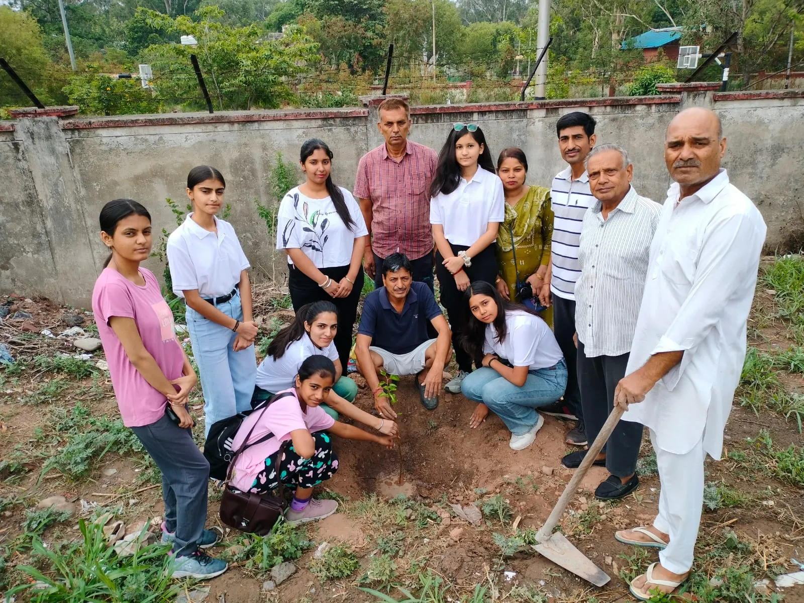 Volunteers gathered around a freshly planted sapling