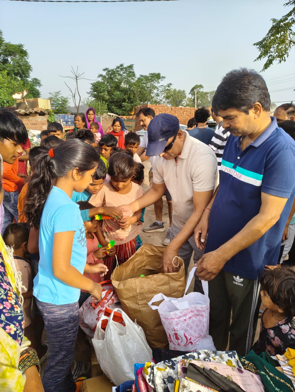 Children receiving small gifts from volunteers at a settlement