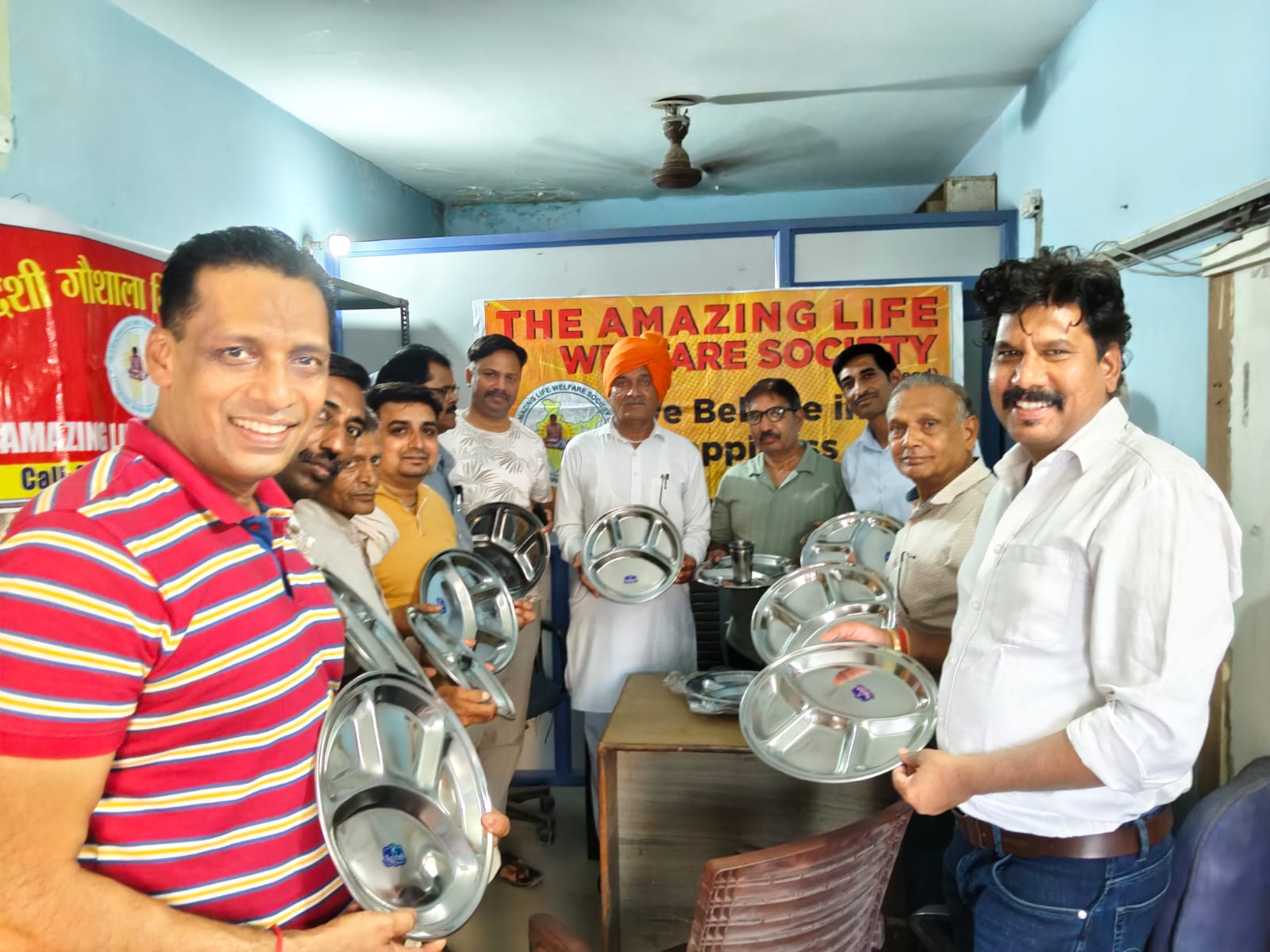 Volunteers with donated steel plates for the community kitchen